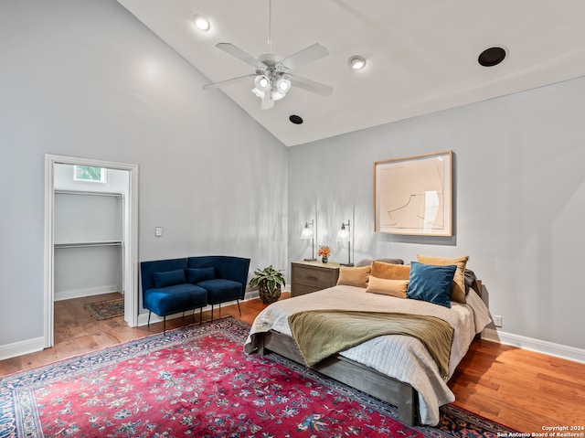 bedroom featuring light wood-type flooring, a spacious closet, ceiling fan, a closet, and high vaulted ceiling