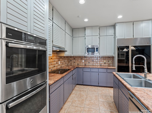 kitchen with light tile patterned flooring, sink, appliances with stainless steel finishes, and tasteful backsplash