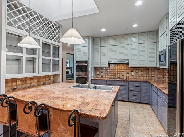 kitchen featuring sink, appliances with stainless steel finishes, light stone countertops, and tasteful backsplash