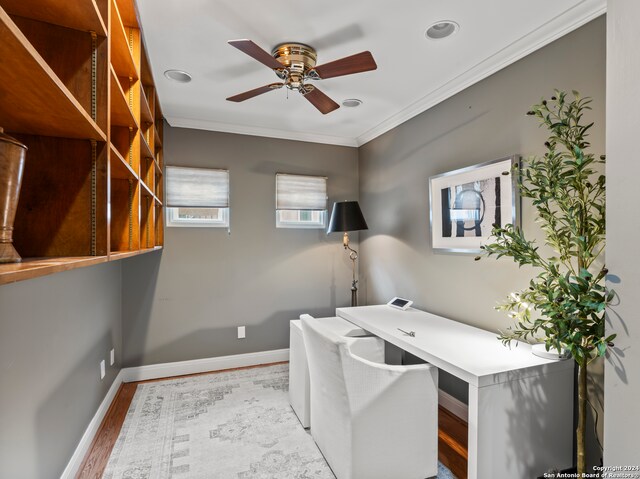 unfurnished office featuring ceiling fan, crown molding, and light hardwood / wood-style flooring