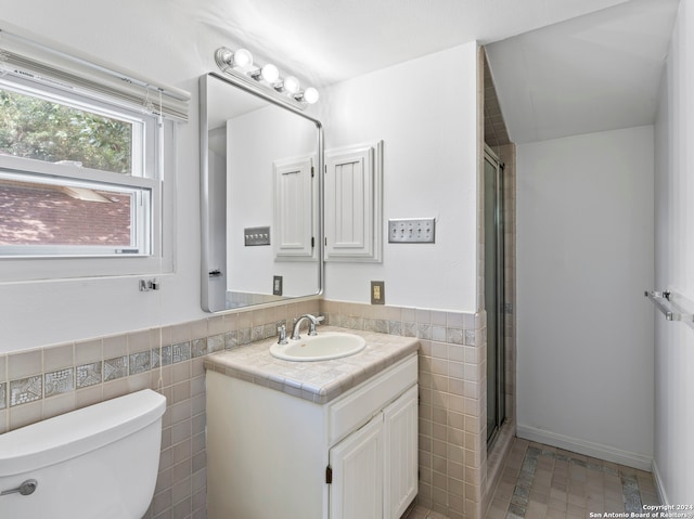 bathroom with tile walls, tile patterned floors, toilet, and vanity