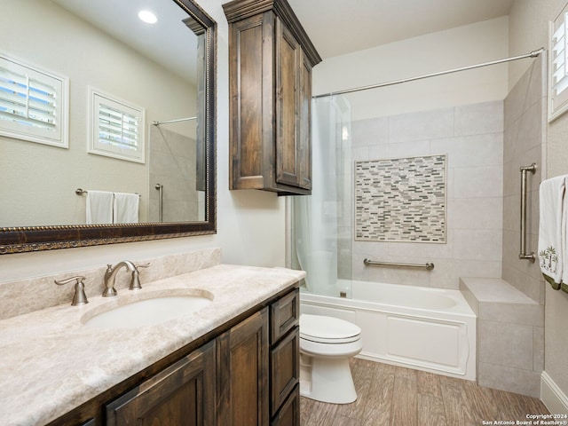 full bathroom with tiled shower / bath, wood-type flooring, toilet, and vanity