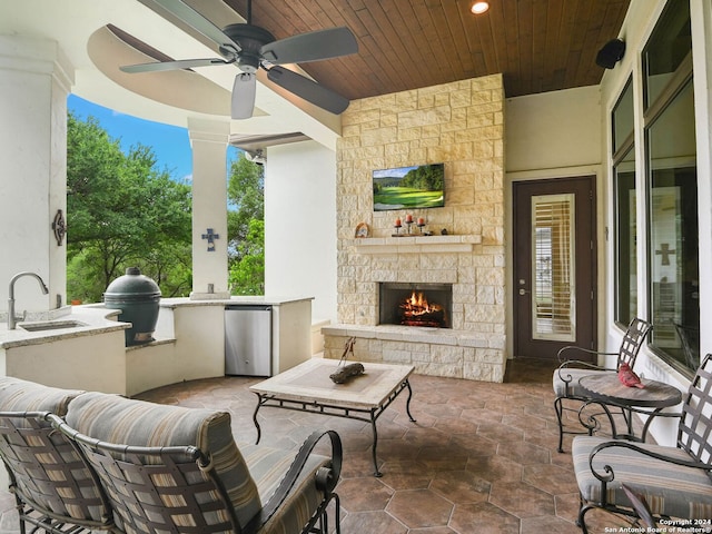 view of patio / terrace with ceiling fan, sink, area for grilling, a grill, and an outdoor stone fireplace