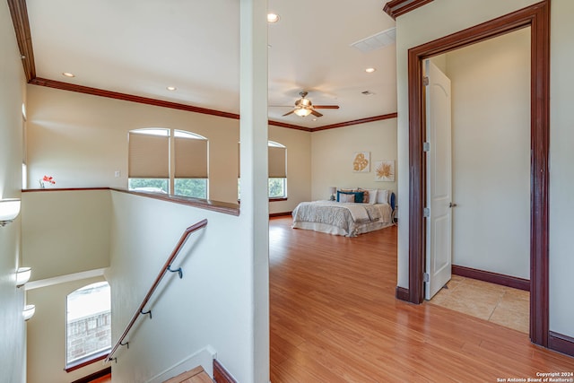 staircase featuring ceiling fan, crown molding, and light wood-type flooring