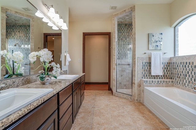 bathroom with tile flooring, independent shower and bath, and dual vanity