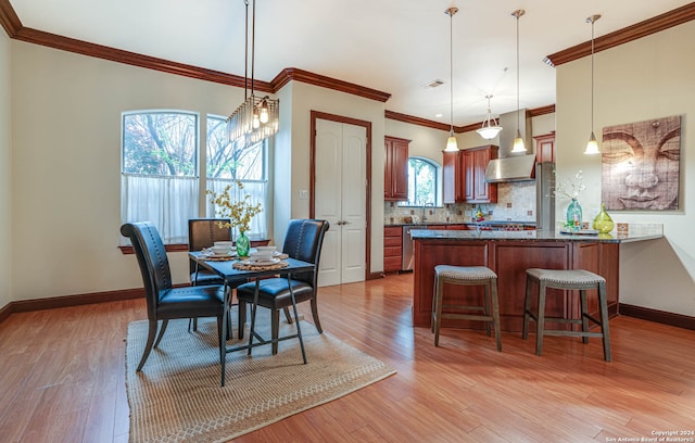 dining area with crown molding, wood-type flooring, and sink