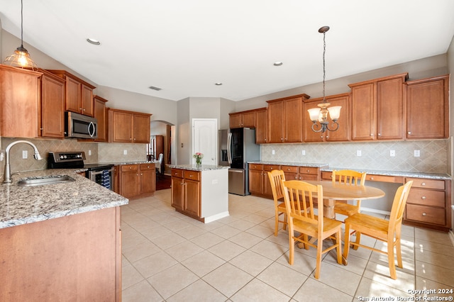 kitchen featuring sink, appliances with stainless steel finishes, tasteful backsplash, and a center island