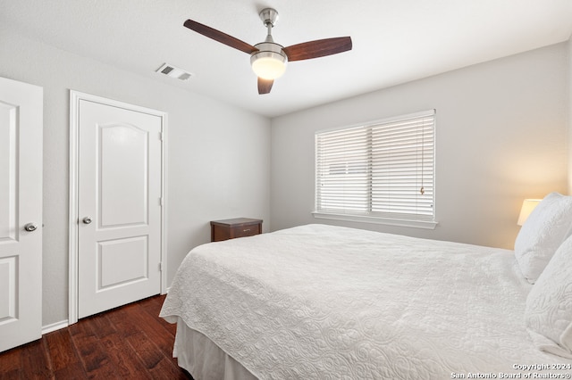 bedroom with dark hardwood / wood-style flooring and ceiling fan