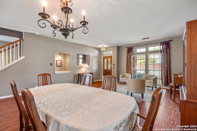 dining space with dark hardwood / wood-style flooring and a chandelier