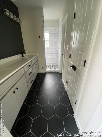 bathroom featuring vanity, tile floors, and a tile shower