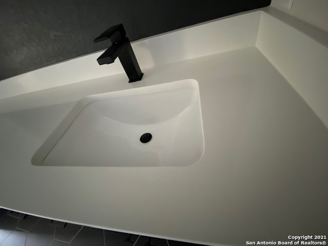 interior details featuring tile flooring and sink