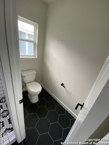 bathroom with toilet and tile floors