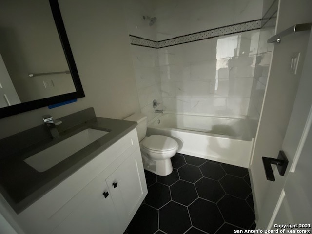 full bathroom with tiled shower / bath, toilet, tile flooring, and vanity