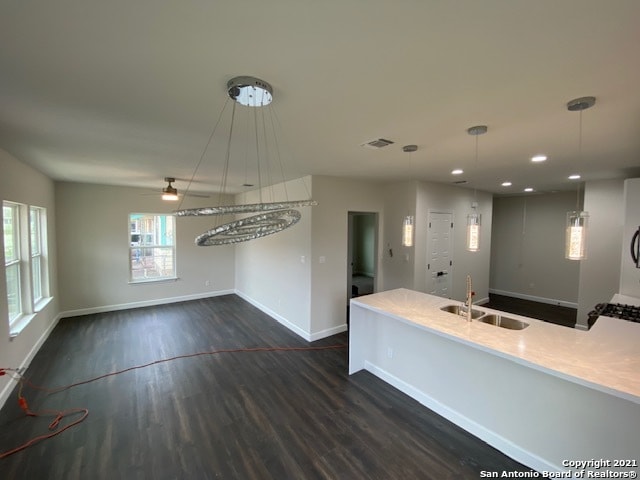 kitchen featuring hanging light fixtures, sink, and dark hardwood / wood-style flooring