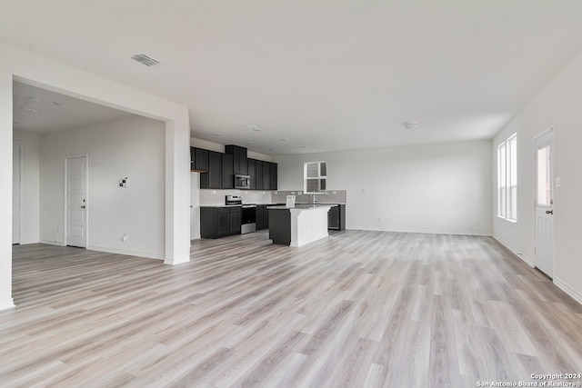 unfurnished living room featuring sink and light hardwood / wood-style flooring