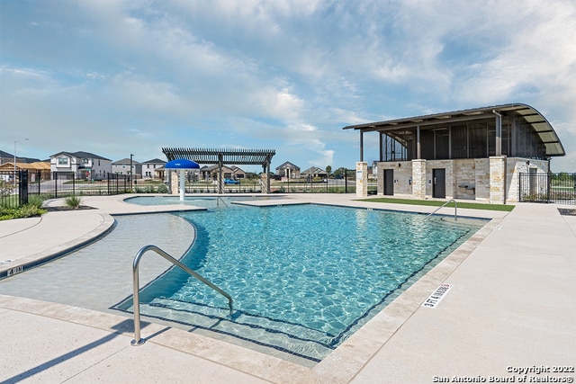 view of swimming pool featuring pool water feature and a patio area