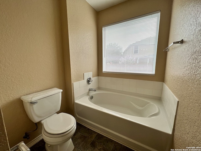 bathroom featuring toilet and a washtub