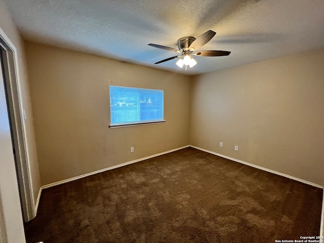 unfurnished room with a textured ceiling, dark carpet, and ceiling fan