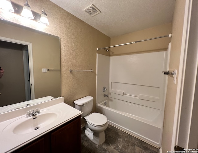 full bathroom featuring shower / bathing tub combination, a textured ceiling, vanity, and toilet