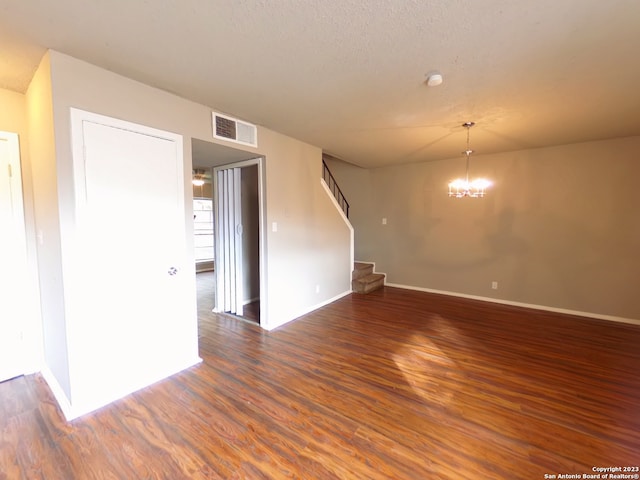 unfurnished room with dark hardwood / wood-style flooring and an inviting chandelier