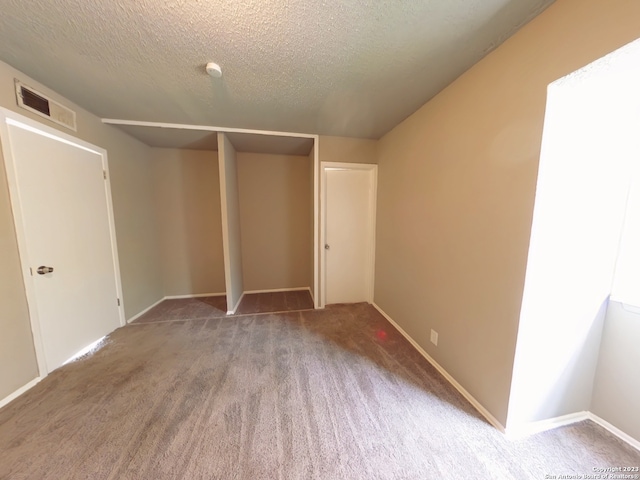 unfurnished bedroom with carpet, a closet, and a textured ceiling