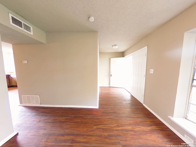 hall with hardwood / wood-style flooring and a textured ceiling