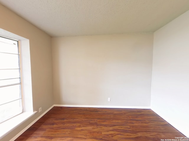 empty room featuring hardwood / wood-style flooring and a textured ceiling