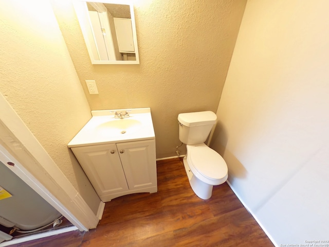 bathroom with hardwood / wood-style floors, vanity, and toilet