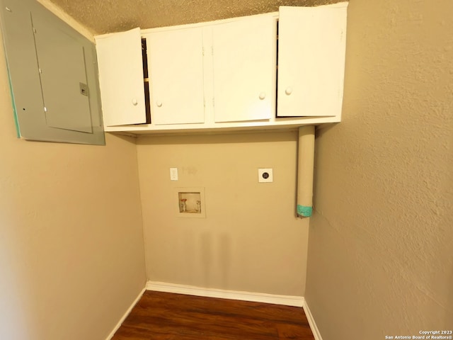 laundry room featuring electric dryer hookup, hardwood / wood-style floors, hookup for a washing machine, cabinets, and a textured ceiling