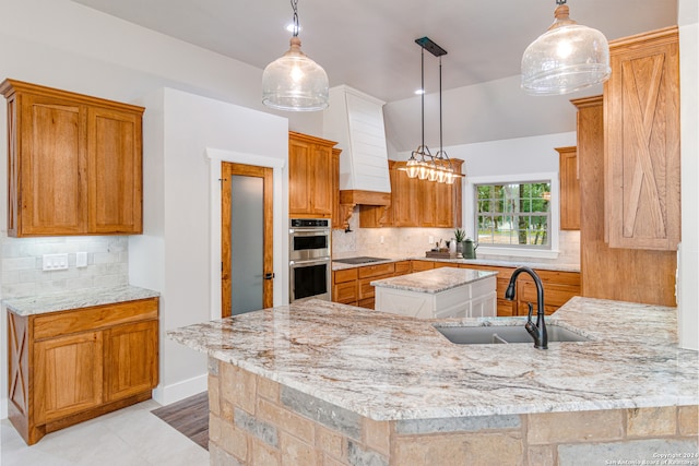 kitchen with a kitchen island, hanging light fixtures, tasteful backsplash, stainless steel double oven, and sink