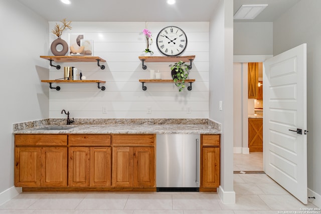 kitchen featuring sink, light stone countertops, and light tile floors