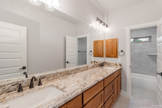 bathroom with tiled shower / bath, double vanity, and tile flooring