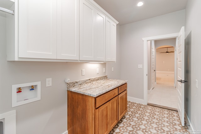 kitchen featuring white cabinets, light tile floors, and light stone counters