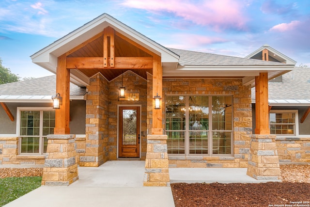 exterior entry at dusk featuring covered porch