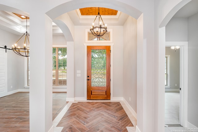 entrance foyer with light parquet floors, a chandelier, and a tray ceiling