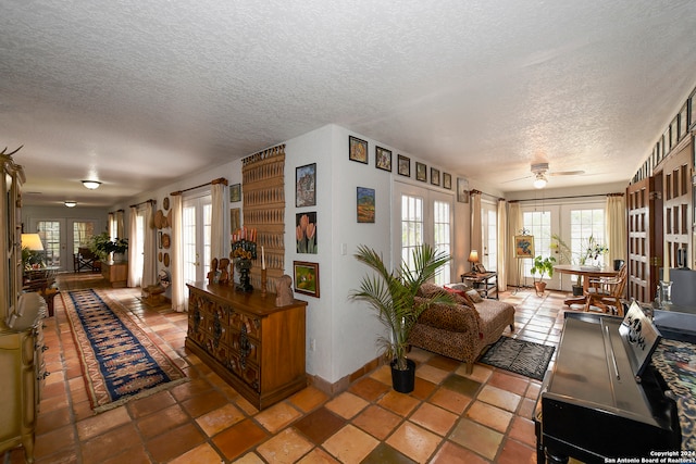 living room with a textured ceiling, french doors, ceiling fan, and tile floors