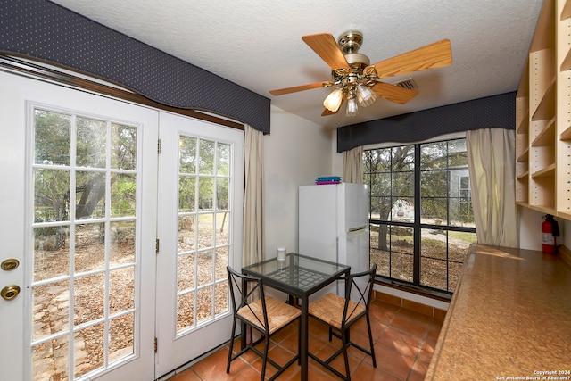 dining room featuring a textured ceiling, ceiling fan, and tile flooring