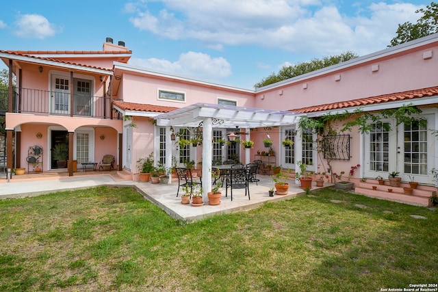 rear view of property with a patio area, french doors, a balcony, and a lawn