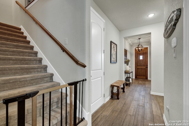 hall featuring a notable chandelier and wood-type flooring