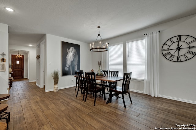 dining room with a healthy amount of sunlight, a textured ceiling, and dark hardwood / wood-style flooring