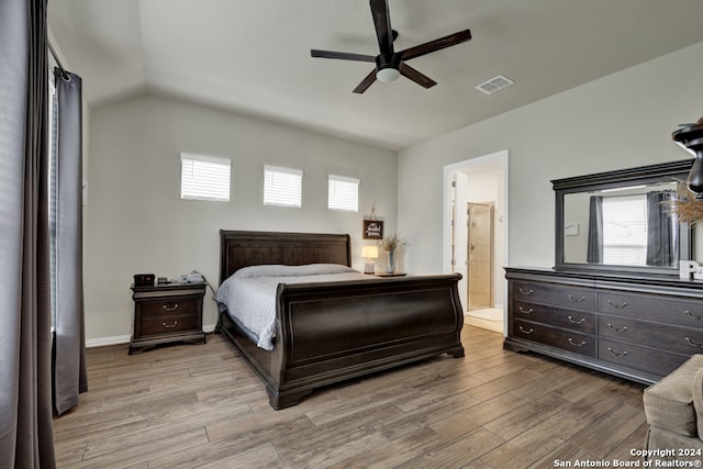 bedroom featuring ceiling fan, vaulted ceiling, hardwood / wood-style flooring, and connected bathroom