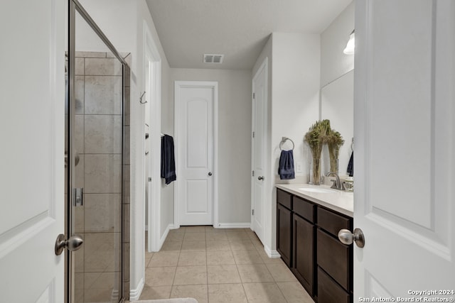 bathroom with tile floors, walk in shower, and vanity