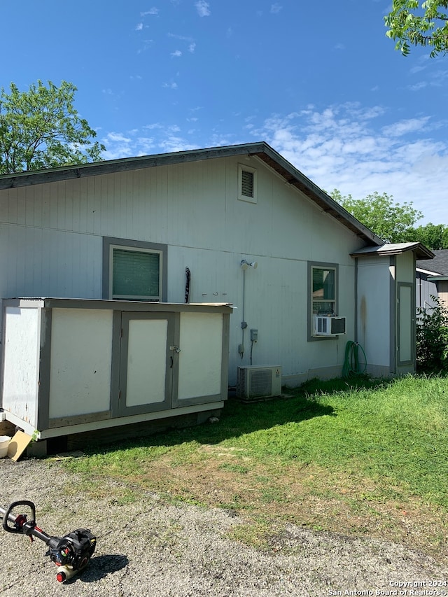 rear view of property featuring a yard and central AC unit