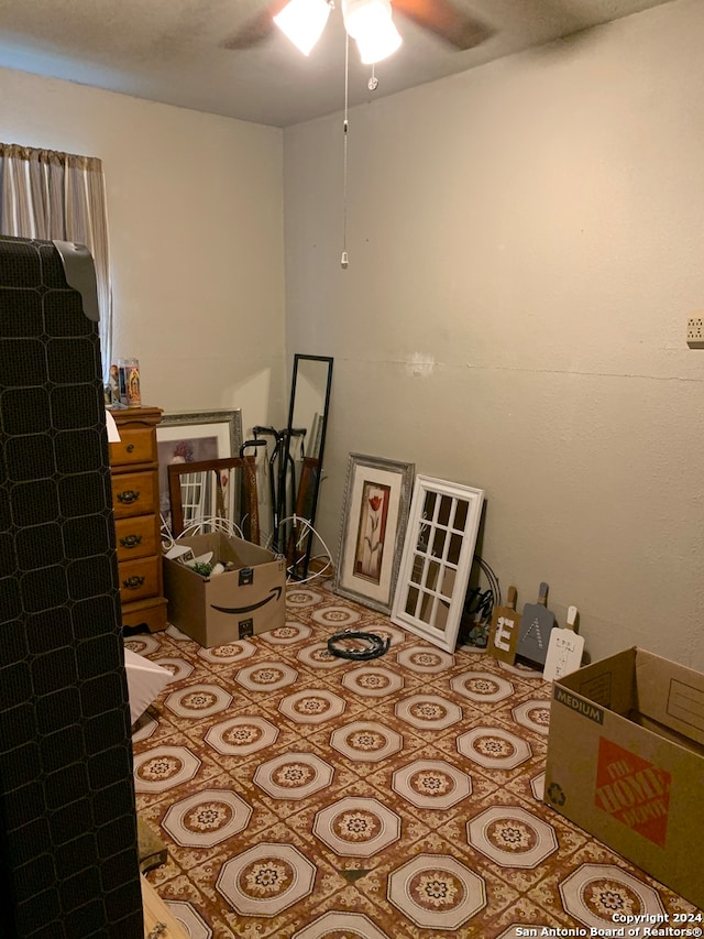 tiled bedroom featuring ceiling fan