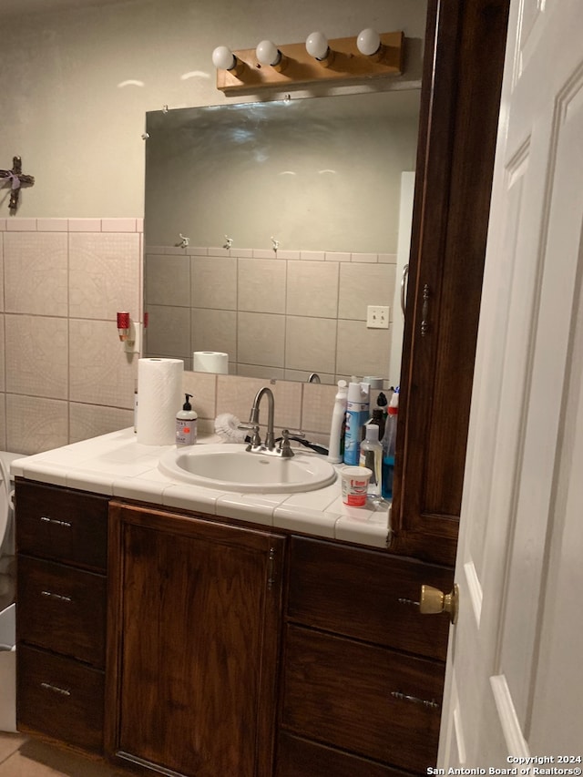 bathroom featuring tile walls, vanity, and tasteful backsplash