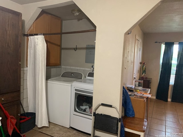 clothes washing area featuring light tile floors and washing machine and clothes dryer