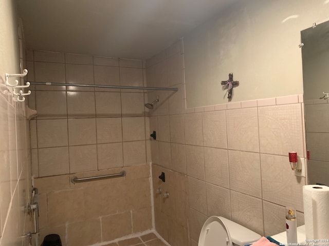 bathroom with toilet and tile walls