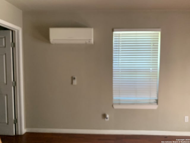 room details with dark hardwood / wood-style floors and a wall unit AC