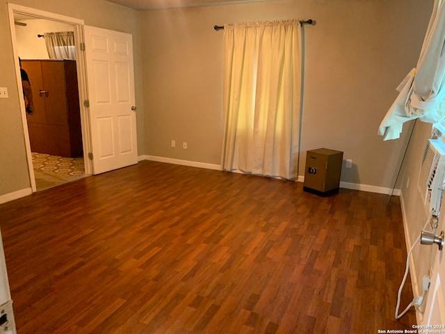 unfurnished room with dark hardwood / wood-style flooring