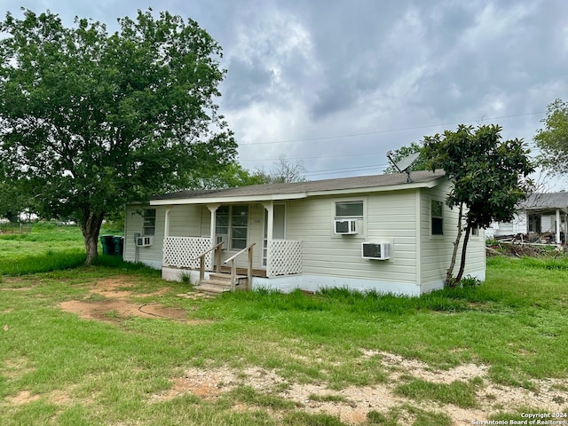 back of house with covered porch and a yard